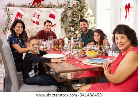 Family With Grandparents Enjoying Christmas Meal At Table