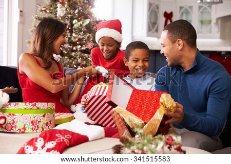 Family Opening Christmas Presents At Home Together