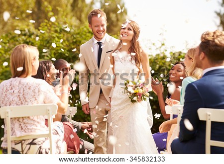 Guests Throwing Confetti Over Bride And Groom At Wedding