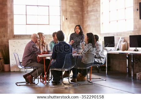 Group Of Designers Having Meeting Around Table In Office