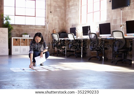 Female Designer Planning Layout On Floor Of Modern Office