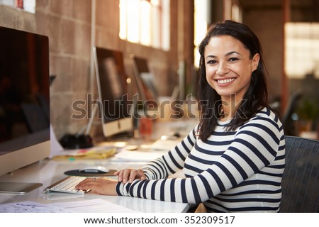 Portrait Of Female Designer Working At Desk In Modern Office