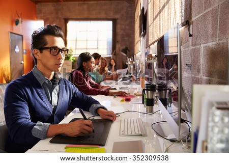 Designers Working At Desks In Modern Office