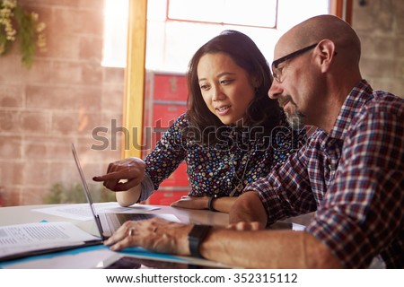 Two Designers With Laptop Meeting In Modern Office