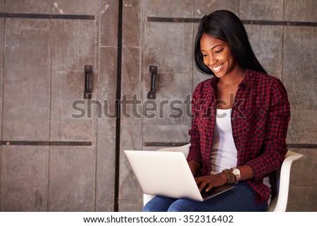 Female Designer In Modern Office Working On Laptop