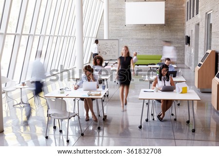 Overhead View Of Businesspeople Working At Desks In Office