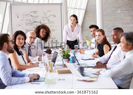 Asian Businesswoman Leading Meeting At Boardroom Table