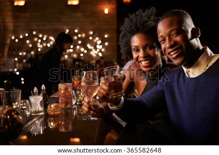 Portrait Of Couple Enjoying Night Out At Cocktail Bar