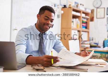 African American male teacher working at his desk