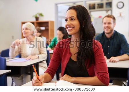 Hispanic woman studying at adult education class looking up