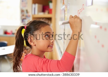 Pupil writing on the board at elementary school maths class