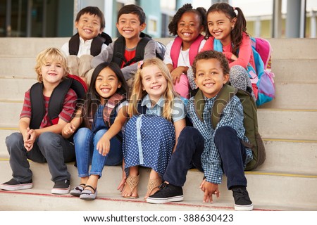 A group of elementary school kids sitting on school steps