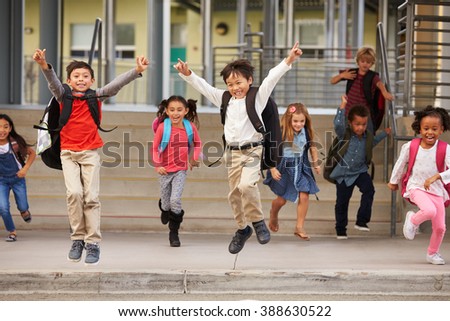A group of energetic elementary school kids leaving school