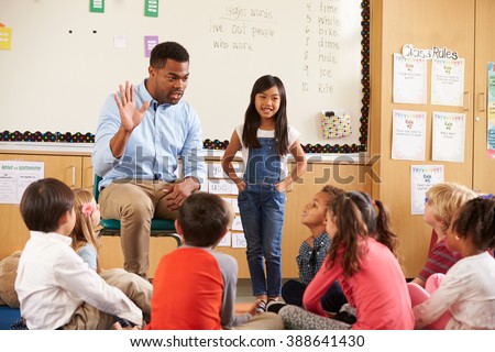 Schoolgirl at front of elementary class with teacher