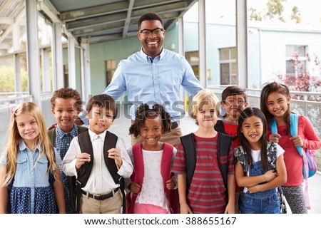 Portrait of elementary school kids and teacher in corridor