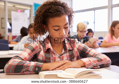Schoolgirl reading at her desk in an elementary school class