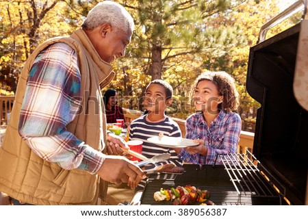 Grandparents With Children Enjoying Outdoor Barbecue