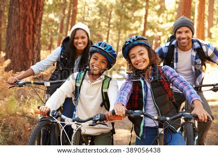Portrait Of Family Cycling Through Fall Woodland