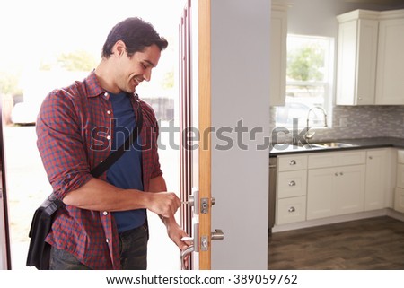 Man Coming Home From Work And Opening Door Of Apartment