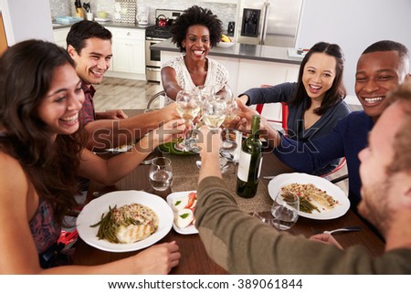 Group Of Friends Making A Toast At Dinner Party