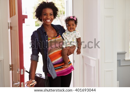 Young black woman holding child arriving home