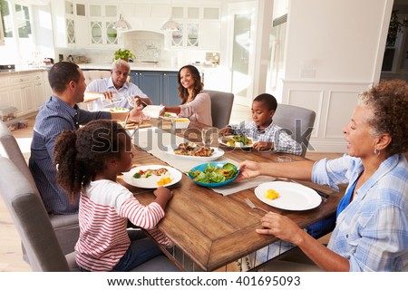Multi generation black family serving a meal in the kitchen