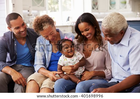 Grandparents, parents and a happy baby girl on mumÃ¢??s knee