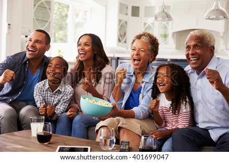 Multi generation black family watching sport on TV at home