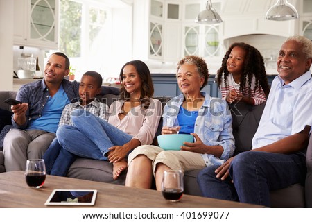 Multi generation black family watching movie on TV together