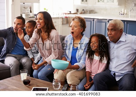 Multi generation black family watching sport on TV at home