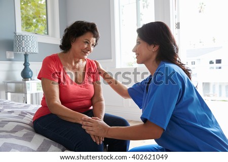 Nurse Making Home Visit To Senior Hispanic Woman