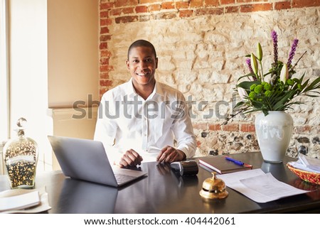 Concierge working at the check in desk of a boutique hotel
