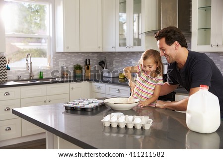 Caucasian girl and dad baking together in the kitchen
