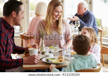 Family Enjoying Meal In Restaurant Together