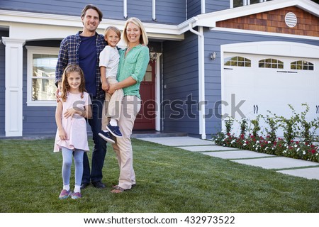 Portrait Of Family Standing Outside House