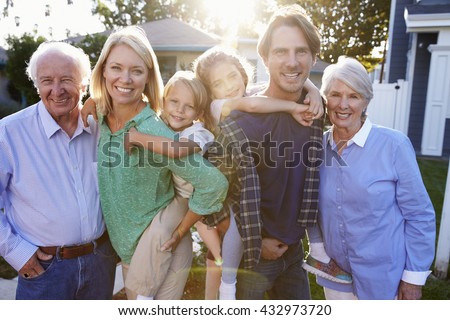 Portrait Of Family With Grandparents Standing Outside House