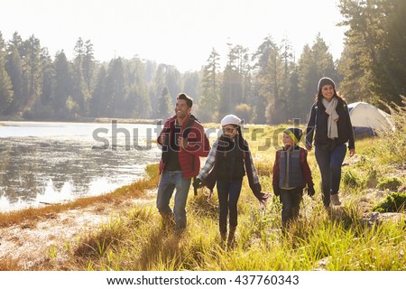 Parents and two children walking near a lake, close up