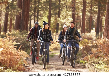 Group of friends on bikes in forest front view