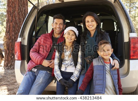 Portrait of family sitting in open back of car before a hike