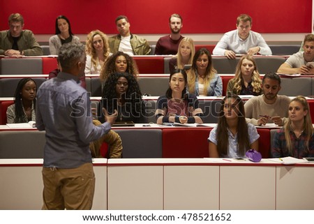 Back view of man presenting to students at a lecture theatre