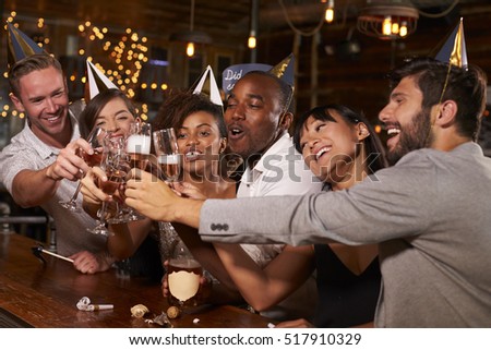 Friends toasting with champagne at New Year party in a bar
