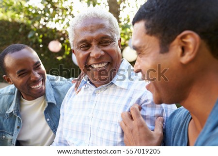 Senior man talking with his adult sons in garden, close up