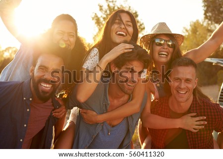 Three couples having fun piggybacking at sundown