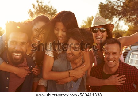 Three couples having fun piggybacking at sundown