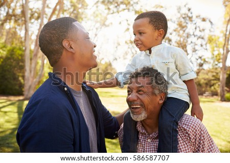 Grandfather With Son And Grandson Having Fun In Park