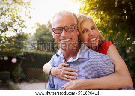 Portrait Of Loving Mature Couple In Back Yard Garden