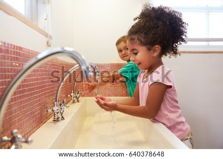 Pupils At Montessori School Washing Hands In Washroom