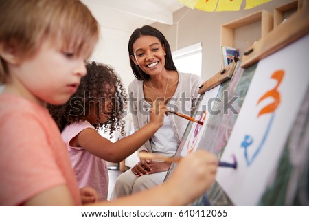 Teacher At Montessori School Helping Children in Art Class