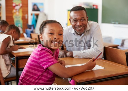 Black teacher and elementary school girl smiling to camera