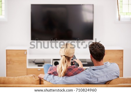 Rear View Of Couple Watching Television Together